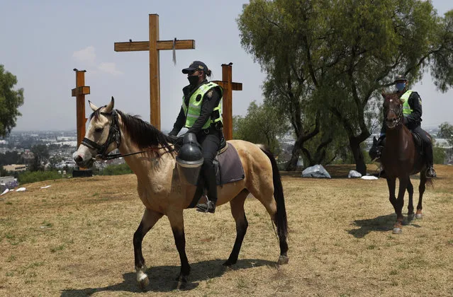 Mounted police guard the La Estrella hill where crosses are located for an annual Holy Week Via Crucis in Iztapalapa, Mexico City, Thursday, April 9, 2020. The area is closed and the police are preventing people from making to the area as a way to help slow down the spread of the new coronavirus. (Photo by Marco Ugarte/AP Photo)