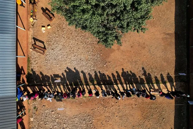 An aerial view shows people line up to cast their votes during the general elections in Eldoret, Kenya on August 9, 2022. (Photo by Baz Ratner/Reuters)