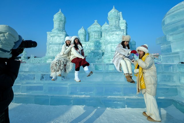 Visitors take souvenir pictures with the ice structures during the Harbin Ice and Snow World in Harbin, China's Heilongjiang province on Monday, January 6, 2025. (Photo by Andy Wong/AP Photo)