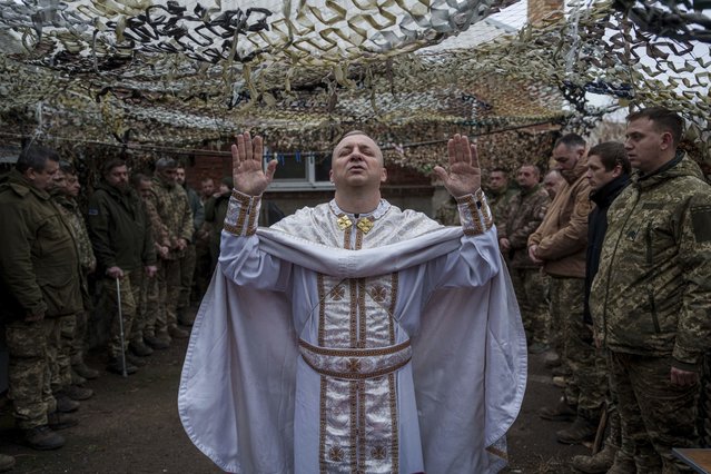 Military chaplain Yurii of the 24th Mechanized Brigade holds a church service for an infantry unit during Christmas near the frontline town of Chasiv Yar, Donetsk region, Ukraine, Wednesday December 25, 2024. (Photo by Evgeniy Maloletka/AP Photo)