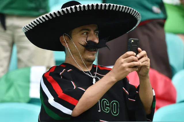 A fan of Mexico takes pictures during the Rio 2016 Olympic Games mens second round Group C football match between Fiji and Mexico, at the Arena Fonte Nova Stadium in Salvador, Brazil on August 7, 2016. (Photo by Nelson Almeida/AFP Photo)