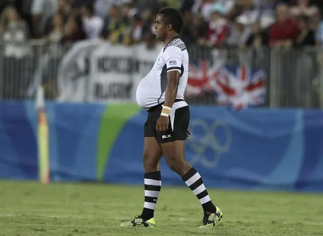 2016 Rio Olympics, Rugby, Men's Gold Medal Match, Fiji vs Great Britain, Deodoro Stadium, Rio de Janeiro, Brazil on August 11, 2016. Kitione Taliga (FIJ) of Fiji walks with the match ball in his shirt as he celebrates their win. (Photo by Phil Noble/Reuters)