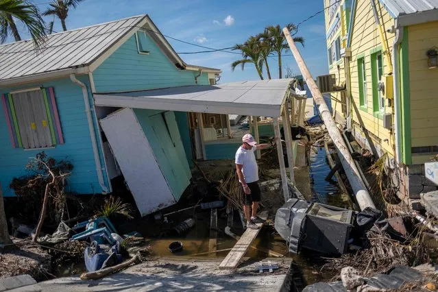 A man stands in front of his destroyed house in the aftermath of Hurricane Ian in Matlacha, Florida on October 3, 2022. The confirmed death toll from Hurricane Ian, which slammed the southeast United States last week, has risen to at least 62, officials said October 2, 2022. (Photo by Ricardo Arduengo/AFP Photo)