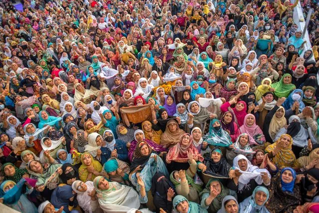 Kashmiri Muslim women devotees look towards a cleric (not seen in the picture) displaying the holy relic believed to be the whisker from the beard of the Prophet Mohammed, at Hazratbal shrine on the, Eid-e-Milad, or the birth anniversary of Prophet Mohammad on October 9, 2022 in Srinagar, Indian administered Kashmir, India. Thousands of Muslims from all over Kashmir visited the Hazratbal shrine in Srinagar to pay obeisance on the Eid-e-Milad, or the birth anniversary of the Prophet Mohammed. The shrine is highly revered by Kashmiri Muslims as it is believed to house a holy relic of the Prophet Mohammed. The relic is displayed to the devotees on important Islamic days such as the Eid- Milad when Muslims worldwide celebrate. (Photo by Yawar Nazir/Getty Images)
