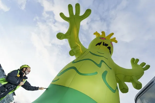 The artist Luke Egan, also known as Filthy Luker, gets Horrible Harvey, his inflatable monster on October 26, 2022, pumped up for his debut at the annual Halloween in the City celebrations in Manchester, United Kingdom this weekend. (Photo by Dominic Lipinski/PA Wire Press Association via Getty Images)