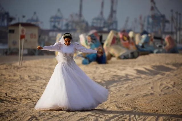 A bride walks on the shore of the Mediterranean Sea as she is photographed before her wedding amid the spread of the coronavirus disease (COVID-19), in Ashdod, Israel on July 6, 2020. (Photo by Amir Cohen/Reuters)