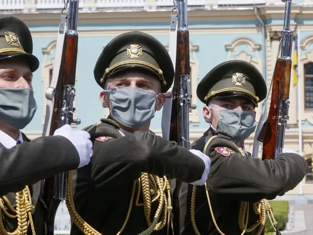 The honor guard soldiers wearing a face mask to protect against coronavirus march during a welcome ceremony the occasion of Swiss Federal president Simonetta Sommaruga's visit in Kyiv, Ukraine, Tuesday, July. 21, 2020. (Photo by Efrem Lukatsky/AP Photo)