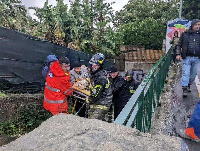 Italian firefighters carry a man out of his house on November 26, 2022 in Casamicciola in the southern Ischia island, following heavy rains that sparked a landslide. (Photo by ANSA via AFP Photo)