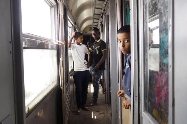 Youths stand on a SNIM train carrying iron ore and mine workers in Zouerate June 24, 2014. (Photo by Joe Penney/Reuters)