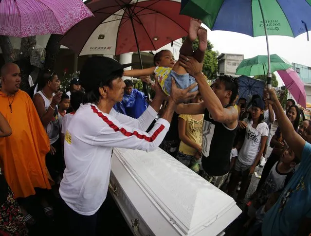 A picture made available on 06 September 2016 shows Filipino relatives carry a baby over the coffin of a slain alleged drug dealer who was killed during a police operation against illegal drugs, during burial rites at a cemetery in Manila, Philippines, 04 September 2016. The White House cancelled the scheduled meeting between US President Barack Obama and Filipino President Rodrigo Duterte on the sideline of the on-going Association of Southeast Asian Nations (ASEAN) Summit to discuss the human rights situation in the Philippines, according to National Security Council spokesman Ned Price. Before leaving for the East Asia summit Philippine President Rodrigo Duterte told reporters that “plenty will be killed until the last pusher is out of the streets”, until the end of his campaign against illegal drugs. (Photo by Francis R. Malasig/EPA)