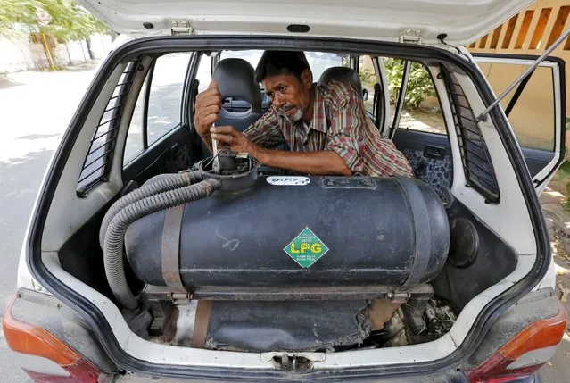A mechanic repairs a pipe of a Liquefied Petroleum Gas (LPG) tank installed in a car outside his workshop in Ahmedabad, India October 6, 2015. Liquefied Petroleum Gas, long a niche product used by the poor to cook and the rich to barbecue, has become a rare bright spot amid a broad commodities rout, riding on the wave of strong economic growth in India and parts of Southeast Asia. (Photo by Amit Dave/Reuters)