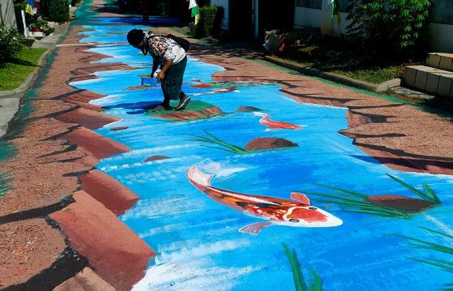 An artist finishes the mural depicting fish pond amid the coronavirus disease (COVID-19) outbreak in Jakarta, Indonesia, August 25, 2020. (Photo by Ajeng Dinar Ulfiana/Reuters)