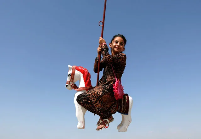 An Afghan girl rides on swings during the first day of the Muslim holiday Eid al-Adha in Kabul, Afghanistan September 12, 2016. (Photo by Mohammad Ismail/Reuters)