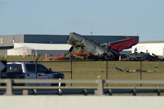 An emergency vehicle sits near debris from two planes that crashed during an airshow at Dallas Executive Airport, Saturday, November 12, 2022. (Photo by L.M. Otero/AP Photo)