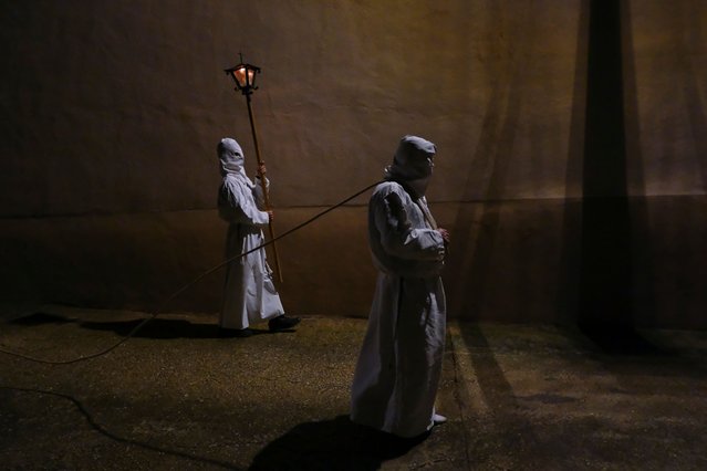 Hooded penitents attend the procession on the Holy Friday, in Torres del Rio, northern Spain, on Friday, March 29, 2024. Hundreds of processions will take place throughout Spain during the Easter Holy Week. (Photo by Alvaro Barrientos/AP Photo)