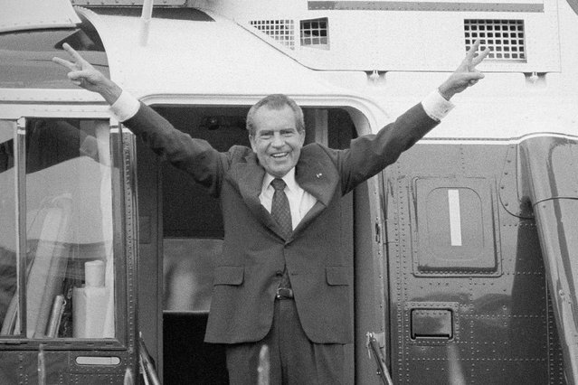 Richard Nixon says goodbye with a victorious salute to his staff members outside the White House as he boards a helicopter after resigning the presidency on August 9, 1974 in Washington. (Photo by Bob Daugherty/AP Photo)