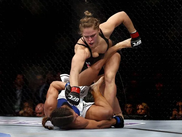 Ronda Rousey punches Liz Carmouche during their UFC 157 Women's Bantamweight Championship mixed martial arts match in Anaheim, February 23, 2013. Rousey won the first women's fight to headline a UFC program by tapout in the first round. (Photo by Jae C. Hong/Associated Press)
