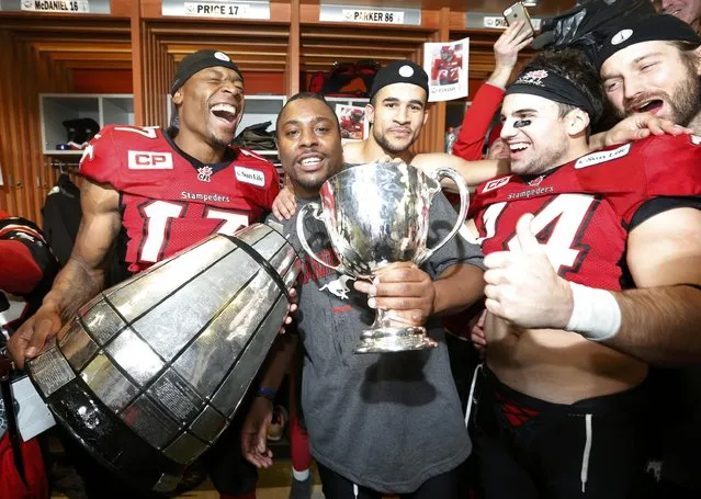 Calgary Stampeders' Maurice Price (L), Nik Lewis (C) and Matt Walter (R) react after breaking the Grey Cup during locker room celebrations after they defeated the Hamilton Tiger Cats in the CFL's 102nd Grey Cup football championship in Vancouver, British Columbia, November 30, 2014. (Photo by Todd Korol/Reuters)