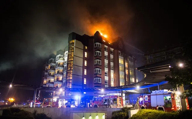 A general view shows firefighters arriving at the scene of a fire burning the upper floors of the Bergmannsheil hospital in Bochum, Germany, 30 September 2016. According to the fire department, two people were killed in the firefight and at least 15 others were injured. (Photo by Marcel Kusch/EPA)