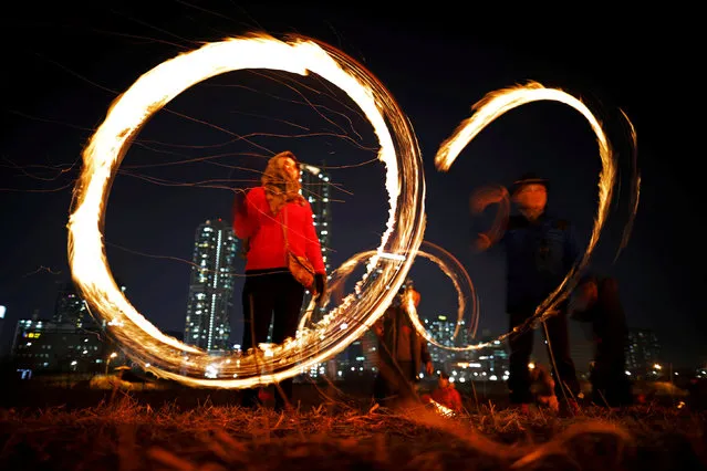 Participants whirl cans filled with burning wood chips during a celebration ahead of “Jeongwol Daeboreum” (Great Full Moon), which is a traditional Korean holiday that celebrates the first full moon of the lunar calendar, at a park in Seoul, South Korea, March 1, 2018. (Photo by Kim Hong-Ji/Reuters)