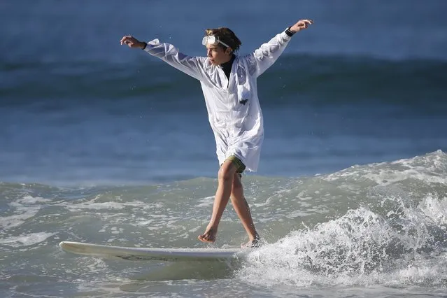 Cooper Colby, 13, surfs dressed as a mad scientist during the ZJ Boarding House Haunted Heats Halloween Surf Contest in Santa Monica, California, United States, October 31, 2015. (Photo by Lucy Nicholson/Reuters)