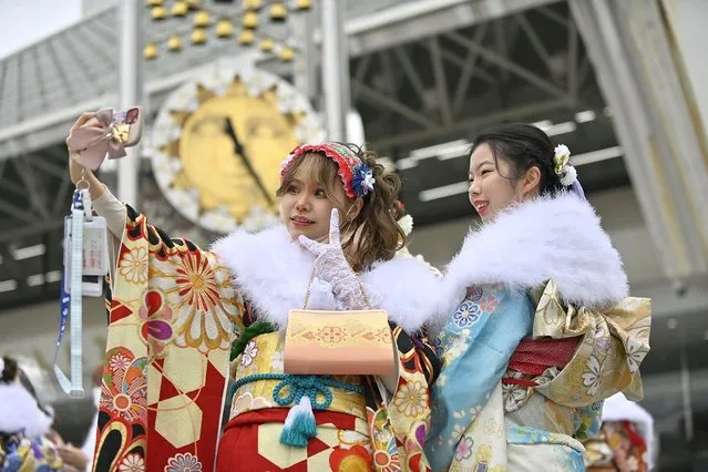 Two young women wearing a traditional Kimono poses for a selfie photo as they attend a ceremony to commemorate the Coming of Age Day of young people entering adulthood in Tokyo, Japan, on January 10, 2022. While the COVID-19 epidemic continues to progress in Japan due to the new Omicron variant, the events that have been organized by the various municipalities of Tokyo have followed a strict sanitary protocol, such as temperature control, disinfection of hands, and the wearing of a protective mask. (Photo by David Mareuil/Anadolu Agency via Getty Images)