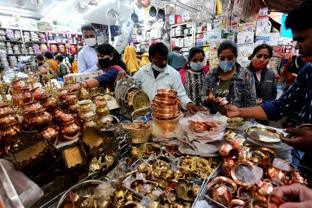 People buy utensils in a shop on the occasion of Dhanteras festival in Bhopal, India, 12 November 2020 . Dhanteras festival is celebrated two days before the Diwali festival on which people buy utensils, gold and silver as it is considered auspicious to mark the festivity. (Photo by Sanjeev Gupta/EPA/EFE)
