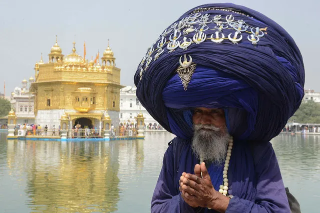 Indian Sikh Nihang (a traditional Sikh religious warrior) Baba 'Jagir' Singh wears a giant turban at the Golden Temple in Amritsar on April 4, 2018, on the eve of the 397th birth anniversary of the ninth Sikh Guru Teg Bahadur. (Photo by Narinder Nanu/AFP Photo)