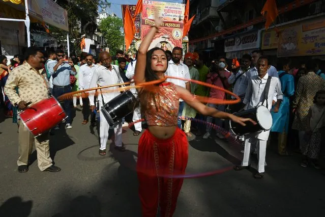 A woman performs during a procession celebrating “Gudi Padwa” or the Maharashtrian New Year, in Mumbai on March 22, 2023. (Photo by Indranil Mukherjee/AFP Photo)