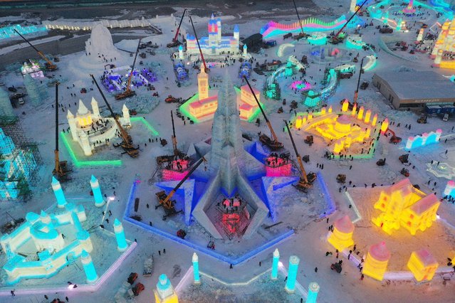 Aerial view of workers and cranes at the construction site of ice sculptures at night at Harbin Ice and Snow World before the 37th Harbin International Ice and Snow Festival on December 20, 2020 in Harbin, Heilongjiang Province of China. (Photo by VCG/VCG via Getty Images)