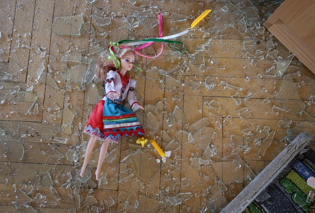 A doll dressed in Ukraine's national dress lies on the floor amid broken glass inside a kindergarten destroyed by a missile strike, in Kyiv on July 10, 2024, amid the Russian invasion in Ukraine. Russia struck cities across Ukraine on July 8, 2024, with a missile barrage that killed 33 people and ripped open a children's hospital in Kyiv. (Photo by Anatolii Stepanov/AFP Photo)