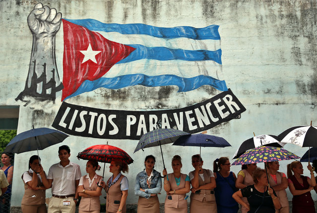Relatives, friends and neighbors of Jorge Luis Guerra, Lirise Cruz Perez and Eddy Antonio Rodriguez, line the streets as family members receive their remains in Velazco, Cuba, 23 May 2018. Guerra, Perez, Rodriguez, were all victims of the Cubana de Aviacion passenger jet crash, which saw more than 100 killed on 18 May. (Photo by Alejandro Ernesto/EPA/EFE)