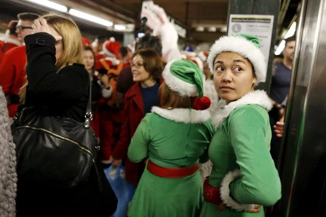 Revelers dressed in Santa Claus and other holiday themed outfits wait for the subway during the annual SantaCon event in the Brooklyn borough of New York, December 12, 2015. (Photo by Brendan McDermid/Reuters)