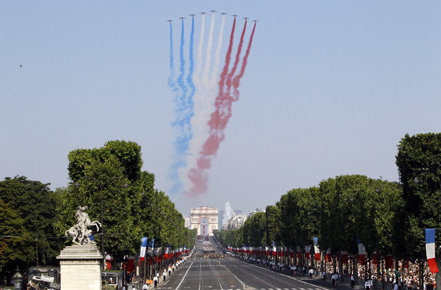 Jets form the Patrouille de France fly over the Champs Avenue at the start of the Bastille Day parade Sunday, July 14, 2013 in Paris. (Photo by Francois Mori/AP Photo)