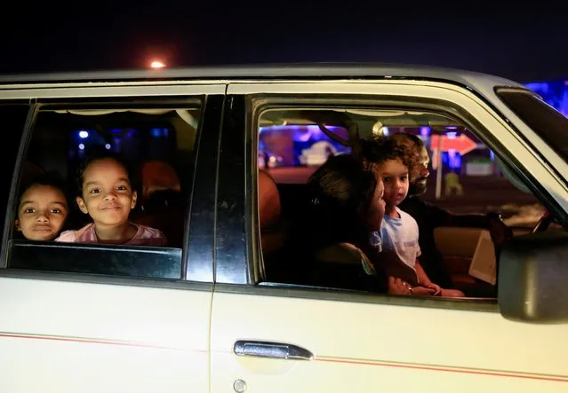 Girls look out of a car window as they watch a screening of the Sudanese European Film Festival at an outdoor, drive-through cinema for visitors, adhering to coronavirus disease (COVID-19) restrictions, in Khartoum, Sudan on February 28, 2021. (Photo by Mohamed Nureldin Abdallah/Reuters)