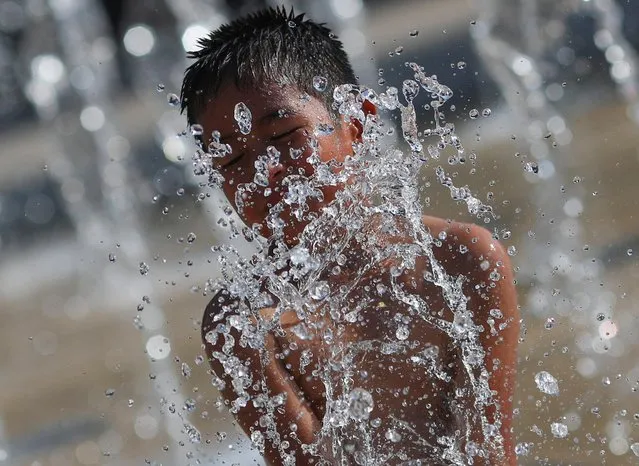 A child cools off in a fountain during a period of high temperatures, at the Monument to the Revolution in Mexico City, Mexico on June 22, 2023. (Photo by Henry Romero/Reuters)