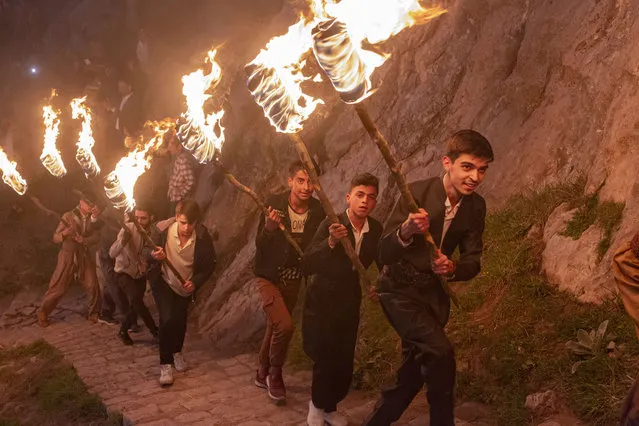 Iraqi Kurds carry lit torches up Kali mountain to celebrate Nowruz, the Persian new year, on March 20, 2021 in Akre, Iraq. The Persian New Year is an ancient Zoroastrian tradition celebrated by Iranians and Kurds which coincides with the vernal (spring) equinox and is calculated by the solar calendar. (Photo by Sam Tarling/Getty Images)