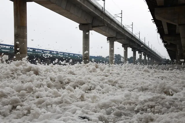 Foam that has gathered in the polluted Yamuna river flies about in the wind in New Delhi on September 23, 2018. (Photo by Dominique Faget/AFP Photo)