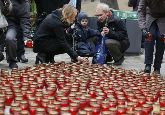 People place lit candles on the ground as they gather to attend a memorial service before the funeral of Russian leading opposition figure Boris Nemtsov in Moscow, March 3, 2015. Several hundred Russians, many carrying red carnations, queued on Tuesday to pay their respects to Boris Nemtsov, the Kremlin critic whose murder last week showed the hazards of speaking out against Russian President Vladimir Putin. REUTERS/Maxim Shemetov 