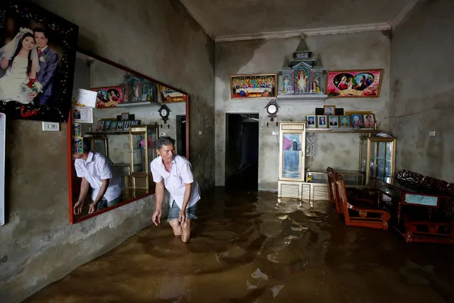 A man cleans his submerged house after heavy rainfall caused by tropical storm Son Tinh in Ninh Binh province, Vietnam, July 22, 2018. (Photo by Reuters/Kham)
