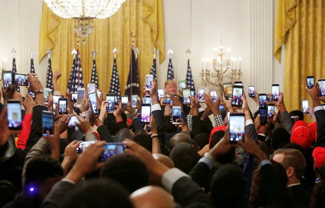 Attendees take photos and videos with their phones of U.S. President Donald Trump as he attends the “2018 Young Black Leadership Summit” in the East Room of the White House in Washington, U.S., October 26, 2018. (Photo by Cathal McNaughton/Reuters)