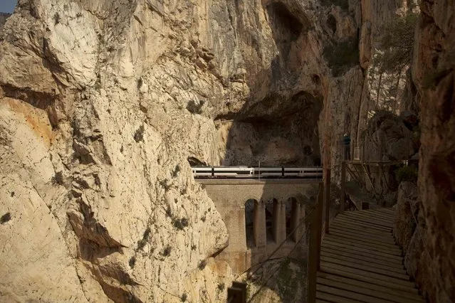 A journalist takes a picture of a train as he walks along the new Caminito del Rey (The King's Little Pathway) in El Chorro-Alora, near Malaga, southern Spain March 15, 2015. (Photo by Jon Nazca/Reuters)