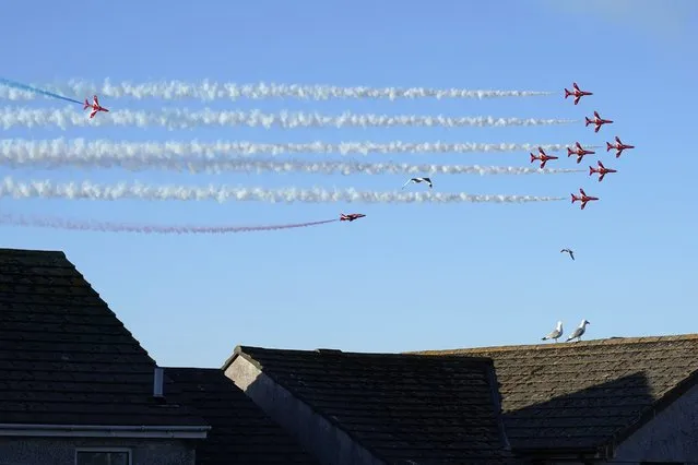 The Red Arrows flight demonstration team performs an aerobatic display above Carbis Bay, England, Saturday, June 12, 2021, during the G-7 summit. The Red Arrows, officially known as the Royal Air Force Aerobatic Team, is the aerobatics display team of the Royal Air Force.  (Photo by Patrick Semansky/AP Photo)
