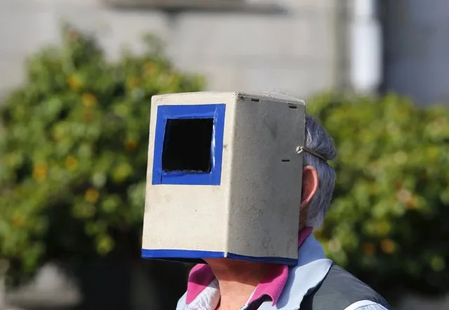 A man uses a special solar visor as he looks at a partial solar eclipse in a square of Pontevedra in the northwest Spain March 20, 2015. (Photo by Miguel Vidal/Reuters)
