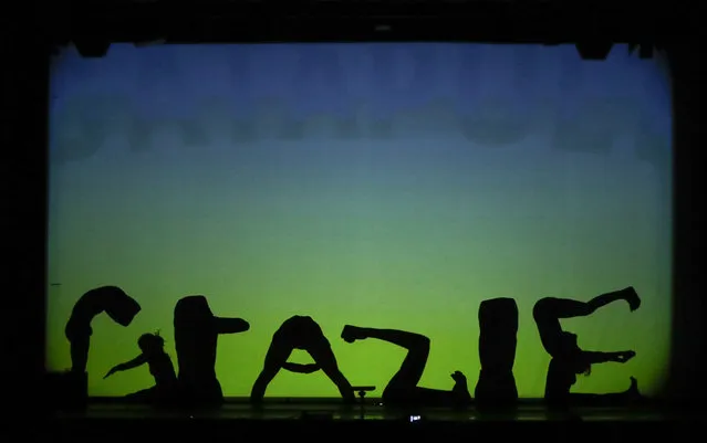 In this photo taken on Tuesday, December 20, 2016, dancers of the U.S. company “Catapult” create the Italian word “Grazie” (Thank you) at the end of their show “Magic Shadows”, in Milan, Italy. (Photo by Luca Bruno/AP Photo)
