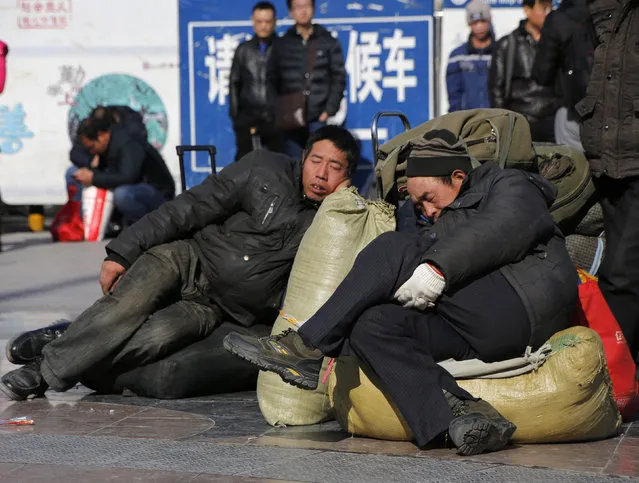 Men sleep on their luggage at a square in front of the Beijing Railway Station before boarding their trains during the travel rush ahead of the upcoming Spring Festival Beijing, China, February 2, 2016. (Photo by Kim Kyung-Hoon/Reuters)