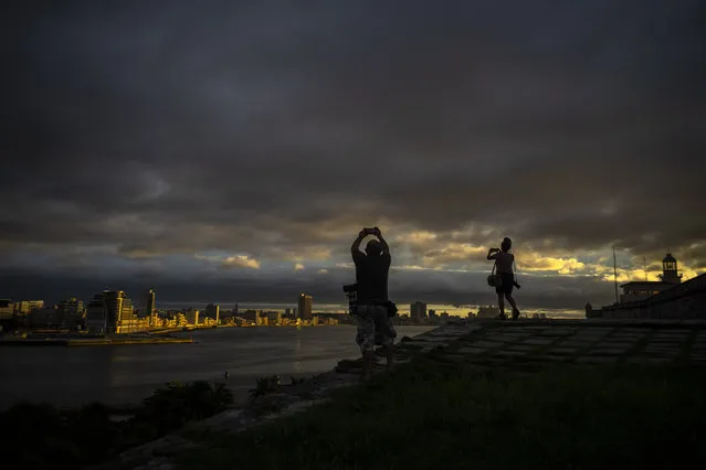 Photographers take pictures of the sky full of clouds after the passage of Tropical Storm Elsa, in Havana, Cuba, Monday, July 5, 2021. (Photo by Ramon Espinosa/AP Photo)