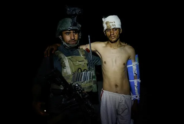 A member of the Afghan Special Forces evacuates an Afghan National Army soldier injured during a firefight with Taliban, who tried to attack a district centre on Sunday, in Kandahar province, Afghanistan, July 12, 2021. (Photo by Danish Siddiqui/Reuters)