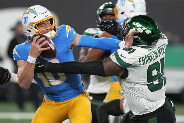 Los Angeles Chargers quarterback Justin Herbert (10) stiff-arms New York Jets defensive end John Franklin-Myers (91) during the second quarter of an NFL football game, Monday, November 6, 2023, in East Rutherford, N.J. (Photo by Seth Wenig/AP Photo)