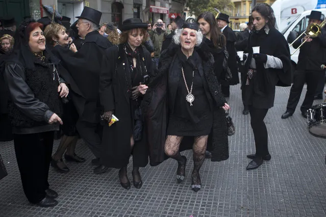 Members of the Alegre brotherhood dance outside a bar in Madrid, Spain, Wednesday, February 10, 2016. The brotherhood stop in various bars for refreshments during a mock funeral procession which traditionally marks the end the carnival. (Photo by Paul White/AP Photo)